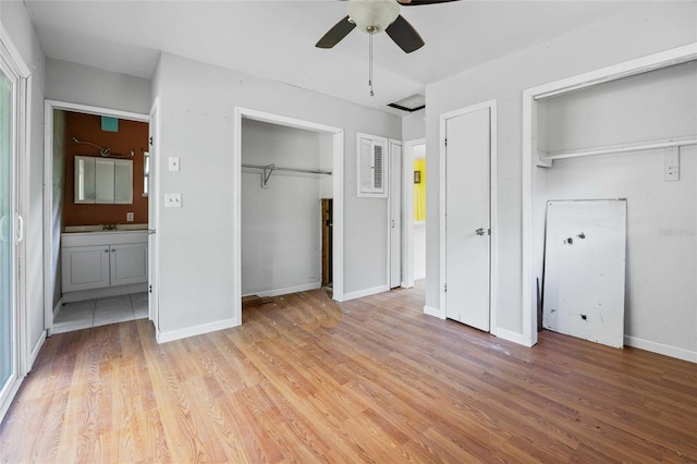 2780 County Road 575, Bushnell, FL 33513 - unfurnished bedroom with baseboards, two closets, a sink, and light wood-style floors