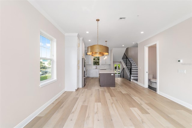 129 SE Watula Ave, Ocala, FL 34471 - kitchen featuring high end fridge, light countertops, white cabinetry, visible vents, and decorative backsplash