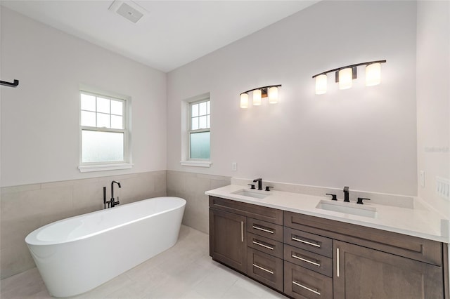 129 SE Watula Ave, Ocala, FL 34471 - full bathroom with a freestanding bath, wainscoting, tile walls, and a sink