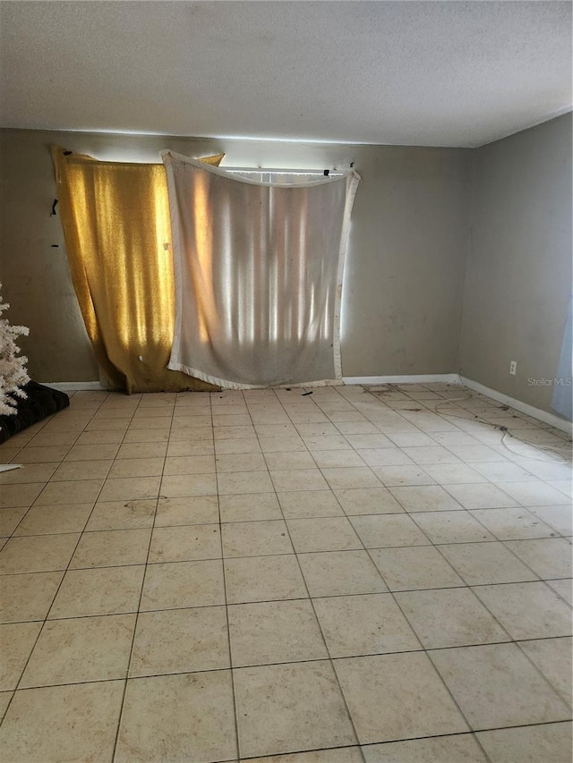 empty room with baseboards and a textured ceiling