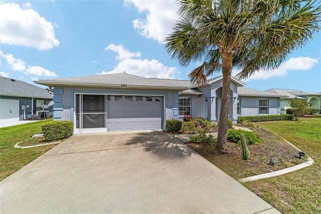 ranch-style home with a garage, stucco siding, and a front lawn