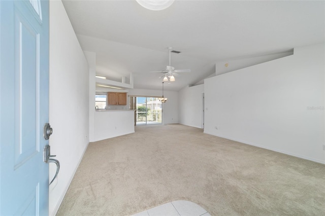 unfurnished living room featuring visible vents, baseboards, ceiling fan with notable chandelier, vaulted ceiling, and light colored carpet