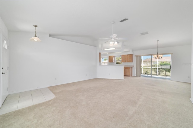 unfurnished living room with light colored carpet, visible vents, ceiling fan with notable chandelier, and vaulted ceiling