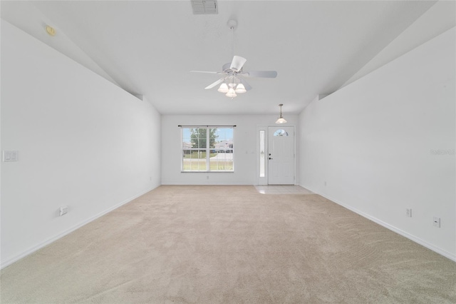 empty room featuring vaulted ceiling, baseboards, light colored carpet, visible vents, and ceiling fan