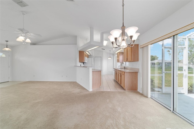 kitchen featuring light countertops, visible vents, a sink, vaulted ceiling, and light colored carpet