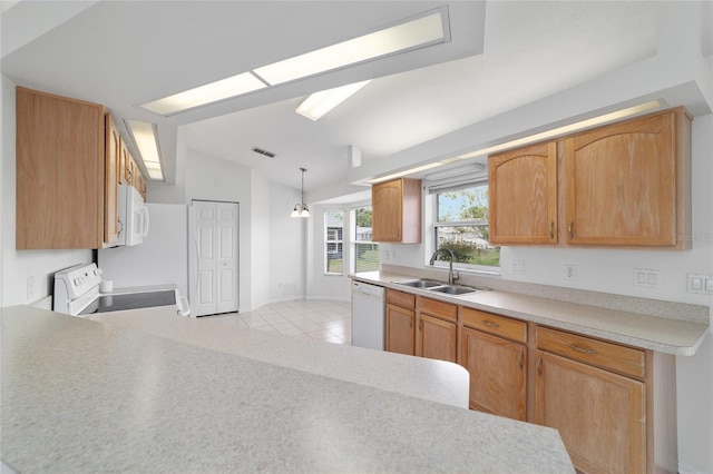 kitchen featuring light countertops, a sink, vaulted ceiling, and white appliances