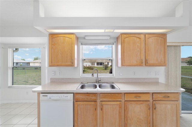 kitchen featuring a sink, light brown cabinetry, dishwasher, and a healthy amount of sunlight