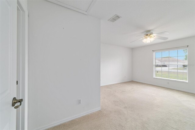 empty room featuring baseboards, carpet flooring, visible vents, and a ceiling fan