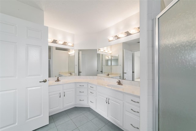 full bathroom featuring double vanity, tile patterned flooring, and a sink