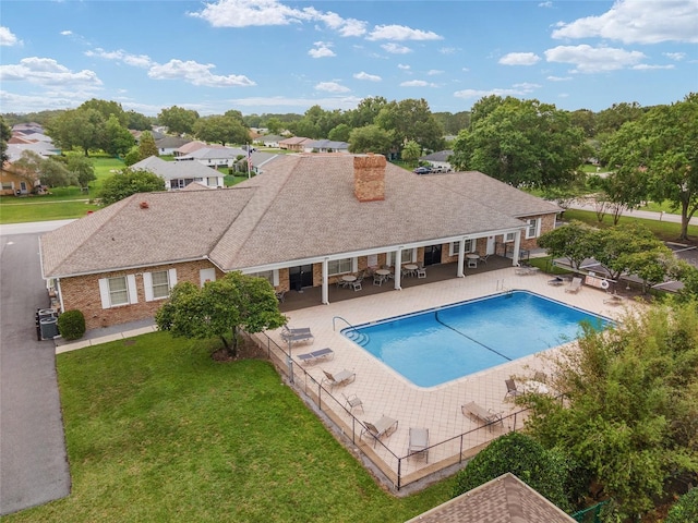 pool with fence, a patio area, and a lawn