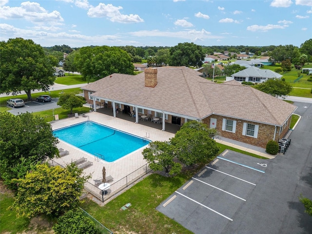 community pool with central air condition unit, fence, and a patio