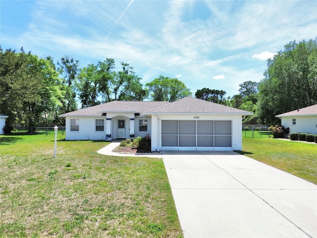 ranch-style house featuring driveway, stucco siding, fence, a front lawn, and a garage
