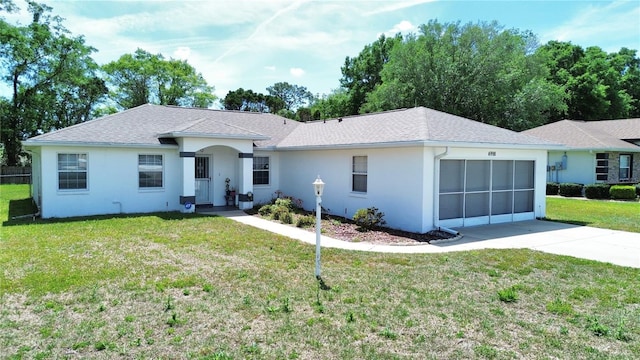 ranch-style home with a front lawn, a garage, driveway, roof with shingles, and stucco siding