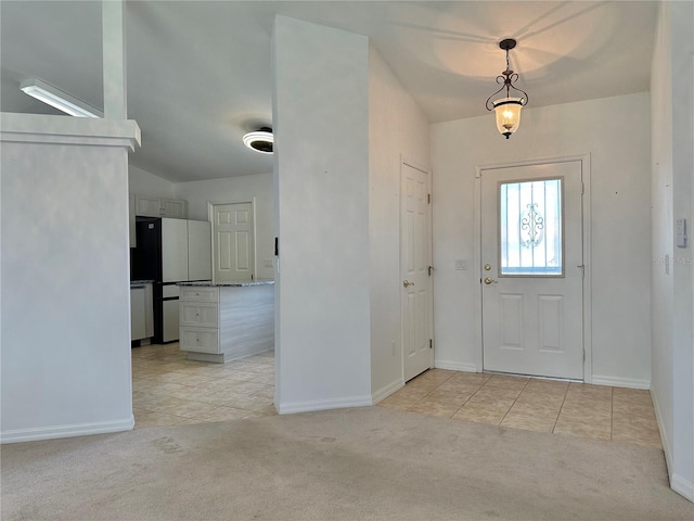 entryway with baseboards, light carpet, and light tile patterned flooring