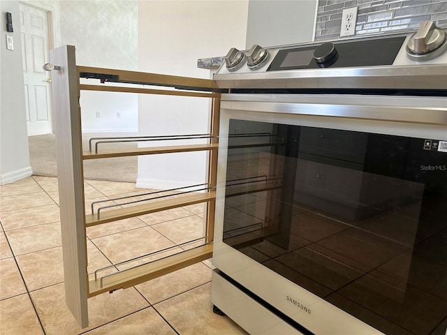 room details featuring baseboards and stainless steel range with electric cooktop