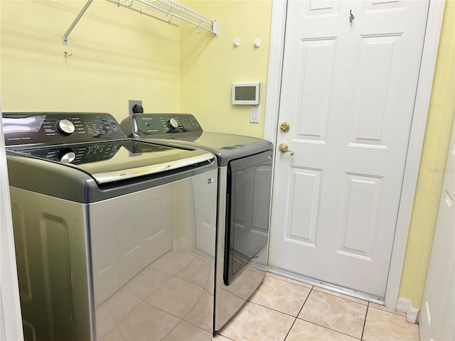 laundry room featuring light tile patterned floors, laundry area, and washing machine and dryer