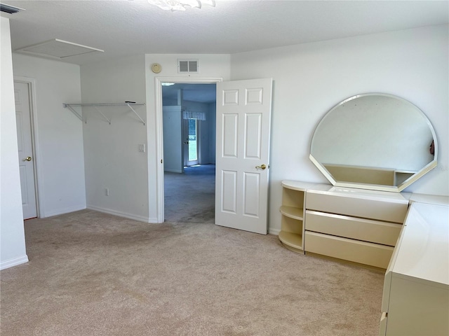 unfurnished bedroom featuring visible vents, light carpet, and baseboards