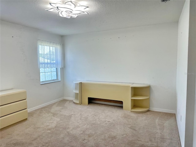 unfurnished bedroom featuring carpet, baseboards, and a textured ceiling