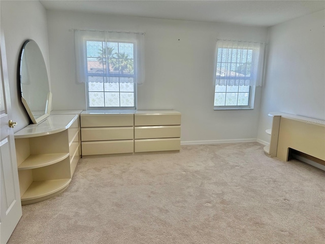 unfurnished bedroom featuring multiple windows and light colored carpet