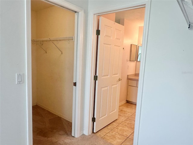 hall with baseboards and light tile patterned flooring