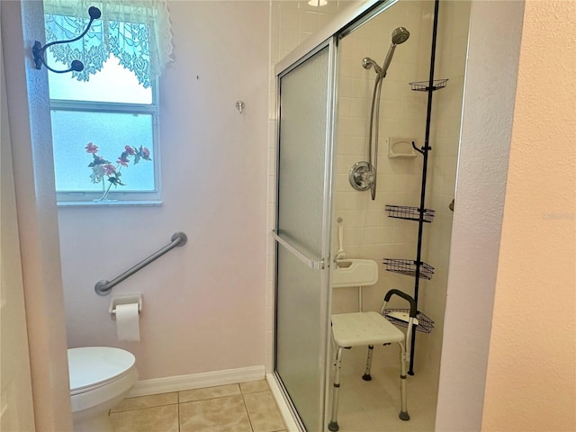full bathroom featuring tile patterned floors, toilet, a stall shower, and baseboards