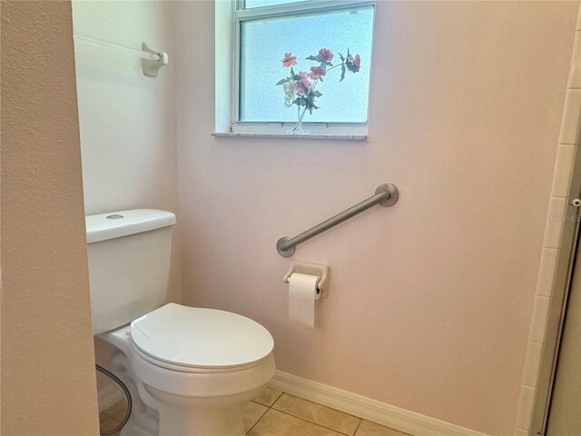 bathroom featuring toilet, tile patterned flooring, and baseboards