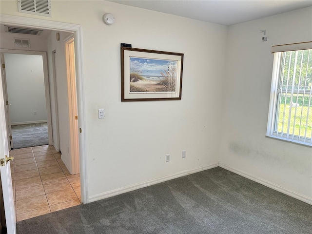 carpeted empty room featuring visible vents and baseboards