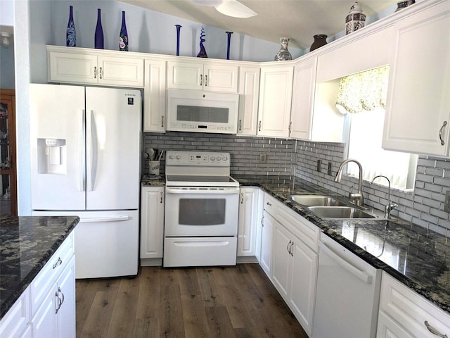 kitchen with tasteful backsplash, white appliances, white cabinets, dark wood finished floors, and a sink