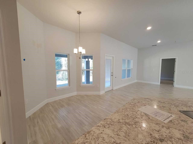 unfurnished room with a chandelier, lofted ceiling, light wood-style flooring, baseboards, and recessed lighting