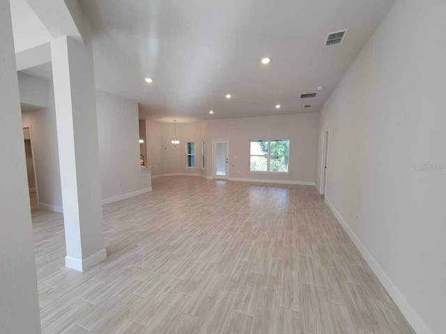unfurnished living room with baseboards, visible vents, light wood-style floors, and recessed lighting