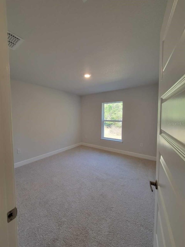 carpeted spare room with recessed lighting, baseboards, and visible vents