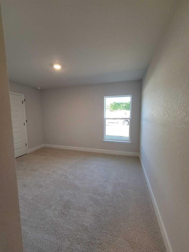 carpeted empty room featuring baseboards and recessed lighting