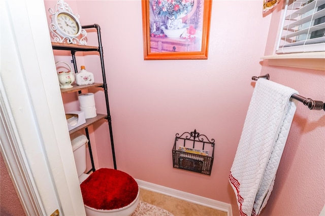 bathroom featuring toilet and baseboards