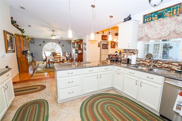 kitchen featuring visible vents, a sink, a ceiling fan, a peninsula, and stainless steel dishwasher