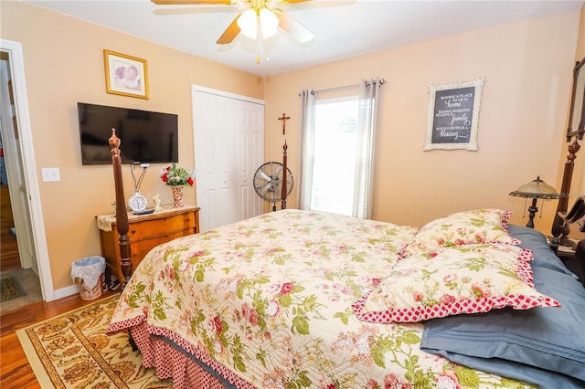 bedroom featuring ceiling fan, a closet, baseboards, and wood finished floors