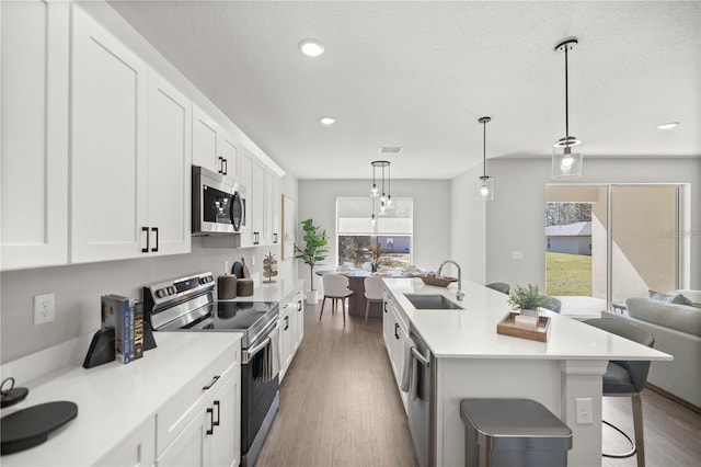 9552 SW 40th Ter, Ocala, FL 34476 - kitchen with appliances with stainless steel finishes, wood finished floors, white cabinetry, and recessed lighting