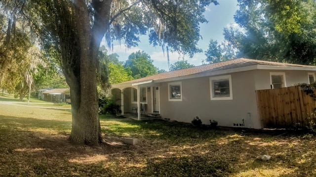 exterior space with a yard, stucco siding, and fence