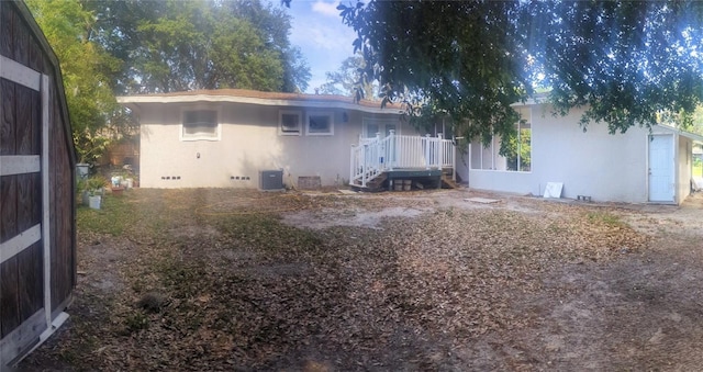 back of property featuring crawl space, central AC, and stucco siding