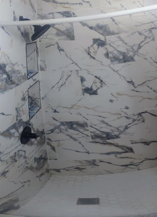 full bathroom featuring a marble finish shower