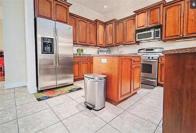 kitchen featuring a center island, ornamental molding, appliances with stainless steel finishes, and light tile patterned floors