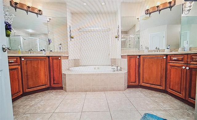 full bath featuring a shower stall, tile patterned floors, a bath, and two vanities