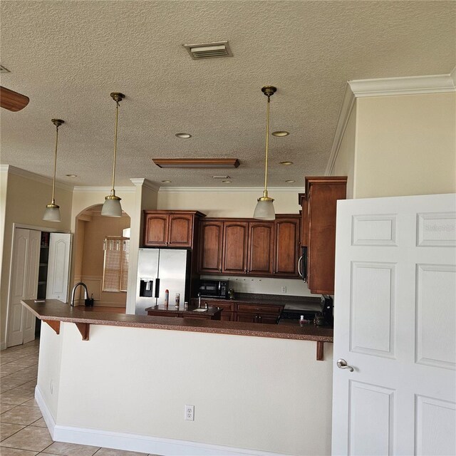 kitchen with visible vents, light tile patterned floors, dark countertops, arched walkways, and stainless steel refrigerator with ice dispenser