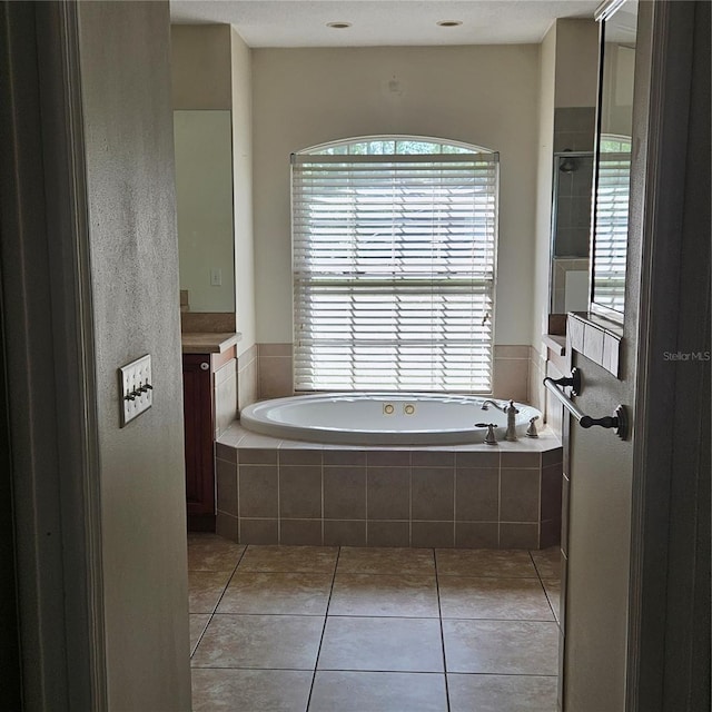 full bathroom featuring a bath, tile patterned floors, and vanity