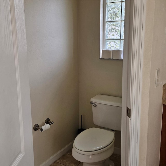 bathroom featuring baseboards, toilet, and tile patterned floors