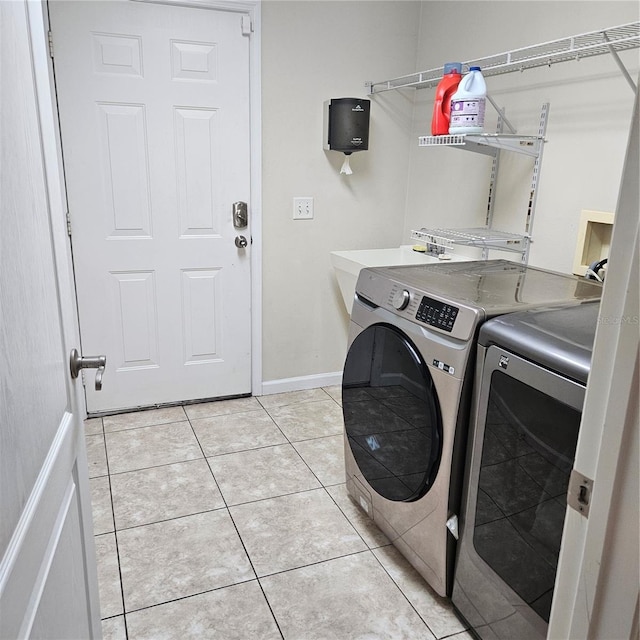 laundry room featuring baseboards, independent washer and dryer, laundry area, and light tile patterned floors