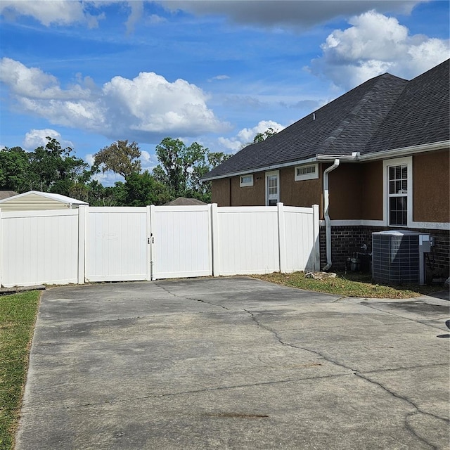 exterior space with driveway and a gate