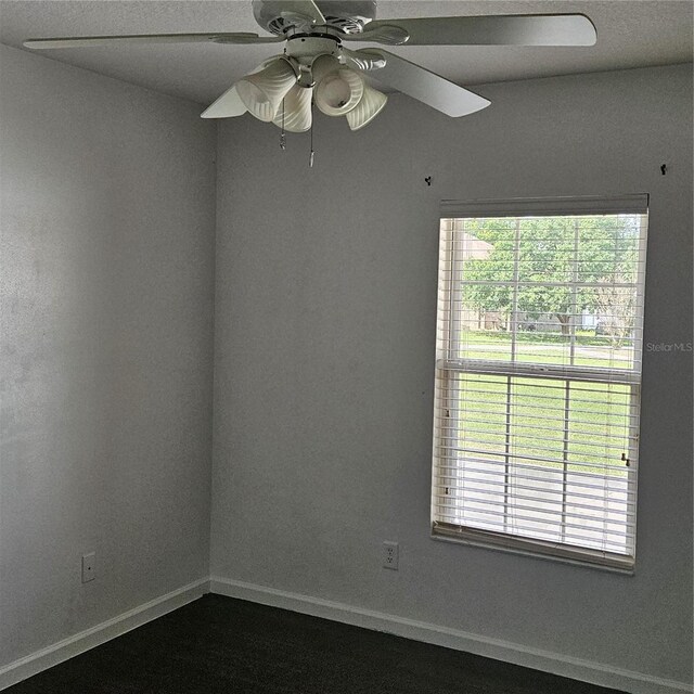 unfurnished room with plenty of natural light, baseboards, and ceiling fan