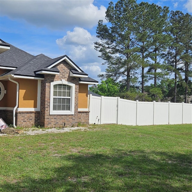 exterior space featuring fence, stucco siding, and a yard