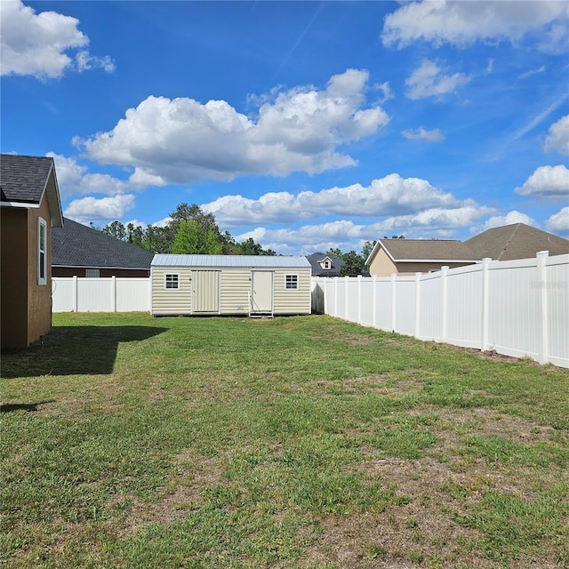 view of yard with an outdoor structure, a fenced backyard, and a storage unit