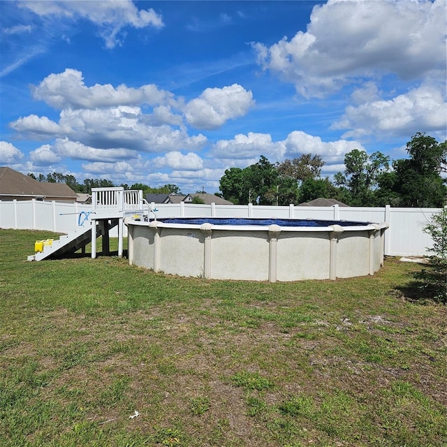 view of yard featuring an outdoor pool and fence